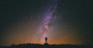 A figure under the Milky Way at night